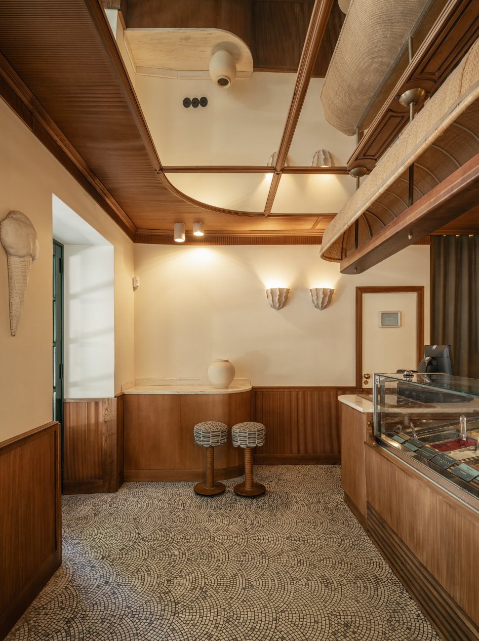 Inside Giola Praça das Flores — wood-panelled room with mosaic floor
